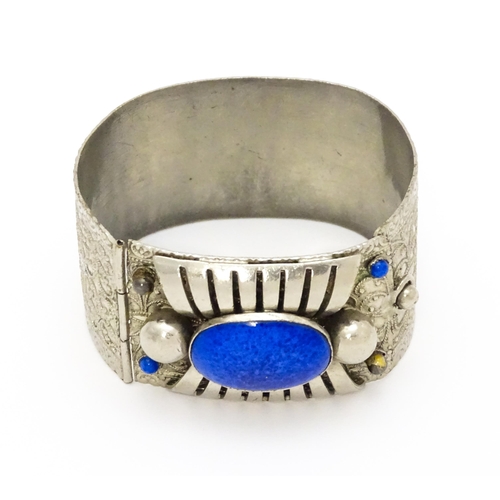 743 - A white metal bracelet of cuff form set with blue cabochon detail.