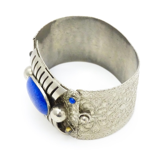 743 - A white metal bracelet of cuff form set with blue cabochon detail.