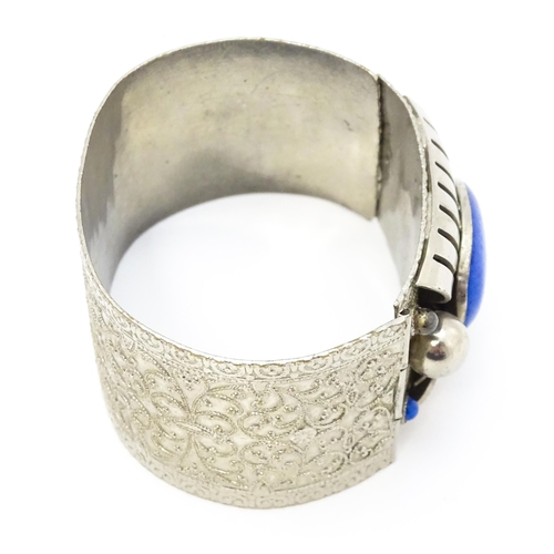 743 - A white metal bracelet of cuff form set with blue cabochon detail.