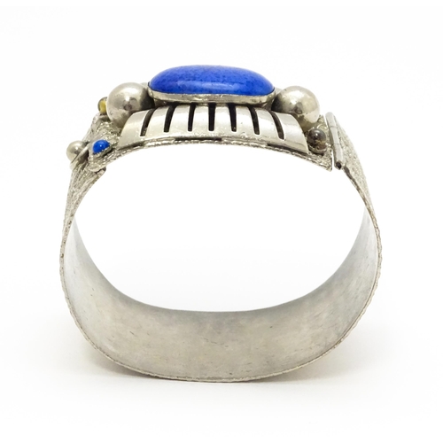 743 - A white metal bracelet of cuff form set with blue cabochon detail.