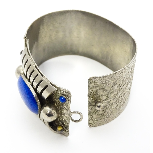 743 - A white metal bracelet of cuff form set with blue cabochon detail.