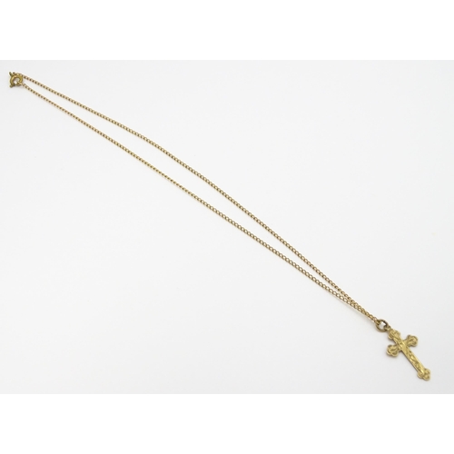 744 - A 9ct gold pendant of cross form, on a yellow metal chain. Pendant approx. 1