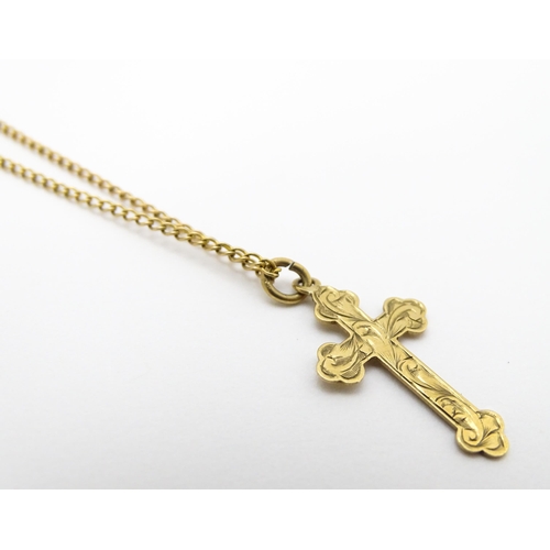 744 - A 9ct gold pendant of cross form, on a yellow metal chain. Pendant approx. 1