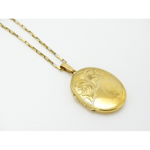 746 - A 9ct gold locket with engraved decoration, on a 9ct gold chain. Locket approx. 1 1/8