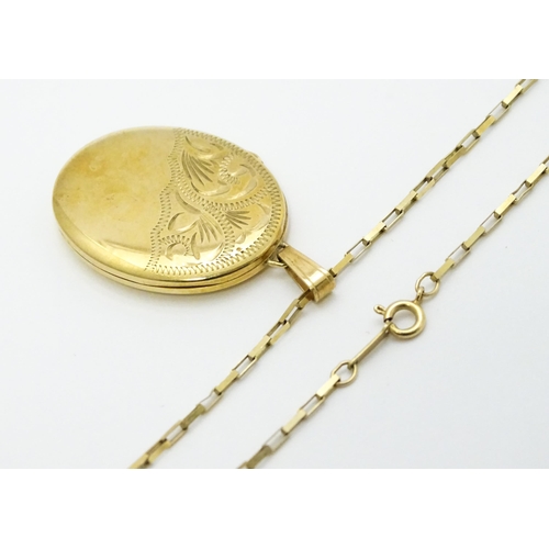 746 - A 9ct gold locket with engraved decoration, on a 9ct gold chain. Locket approx. 1 1/8