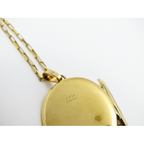 746 - A 9ct gold locket with engraved decoration, on a 9ct gold chain. Locket approx. 1 1/8