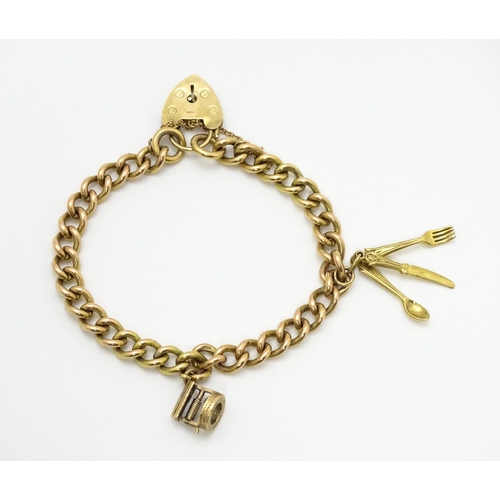 747 - A 9ct gold bracelet with padlock clasp and set with two 9ct gold charms, one a wishing well, the oth... 