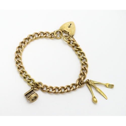 747 - A 9ct gold bracelet with padlock clasp and set with two 9ct gold charms, one a wishing well, the oth... 