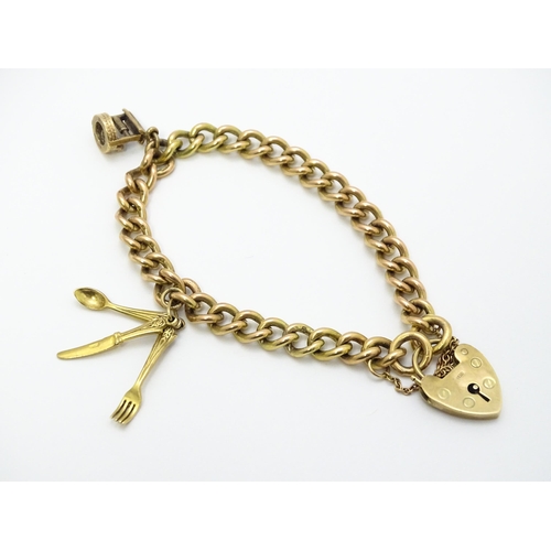 747 - A 9ct gold bracelet with padlock clasp and set with two 9ct gold charms, one a wishing well, the oth... 