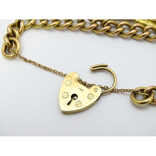 747 - A 9ct gold bracelet with padlock clasp and set with two 9ct gold charms, one a wishing well, the oth... 