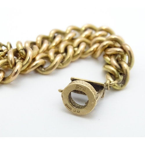 747 - A 9ct gold bracelet with padlock clasp and set with two 9ct gold charms, one a wishing well, the oth... 