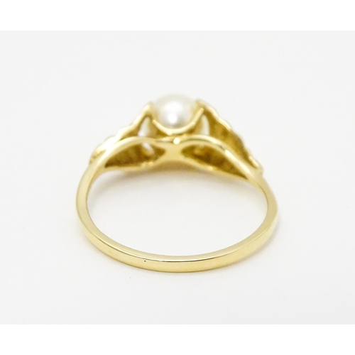 749 - A 14ct gold ring set with central pearl. Ring size approx. M. Together with a pair of stud earrings ... 