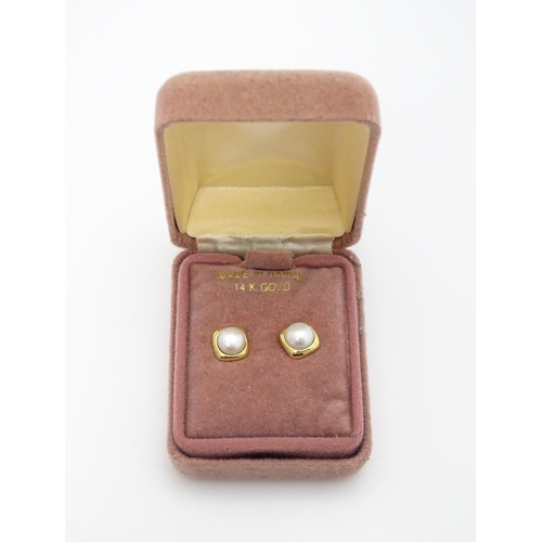 749 - A 14ct gold ring set with central pearl. Ring size approx. M. Together with a pair of stud earrings ... 