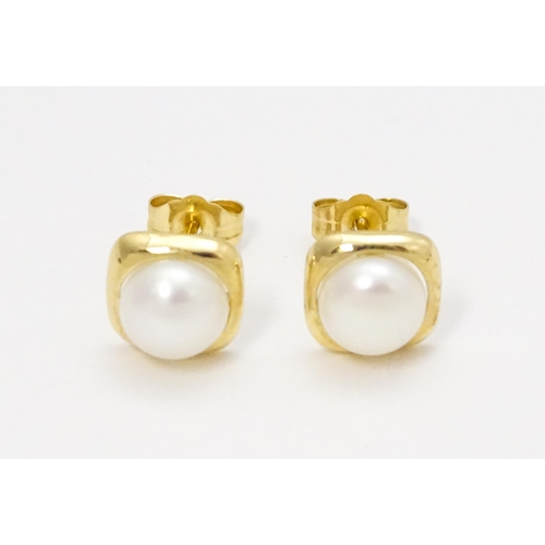 749 - A 14ct gold ring set with central pearl. Ring size approx. M. Together with a pair of stud earrings ... 