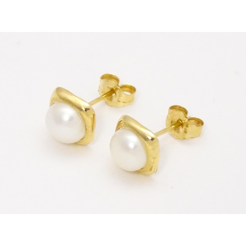 749 - A 14ct gold ring set with central pearl. Ring size approx. M. Together with a pair of stud earrings ... 