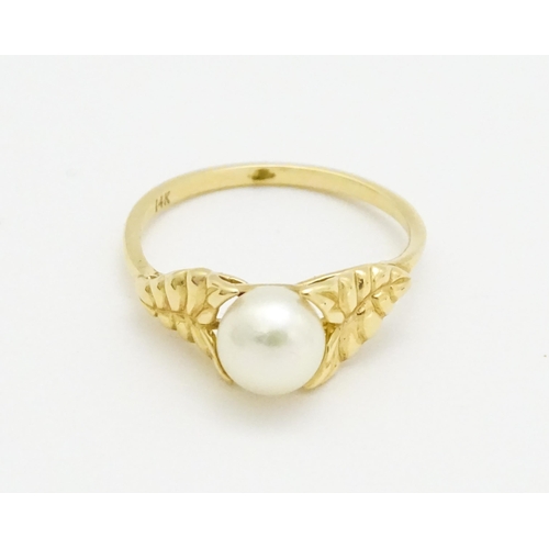 749 - A 14ct gold ring set with central pearl. Ring size approx. M. Together with a pair of stud earrings ... 