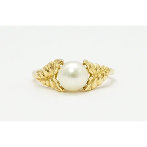 749 - A 14ct gold ring set with central pearl. Ring size approx. M. Together with a pair of stud earrings ... 