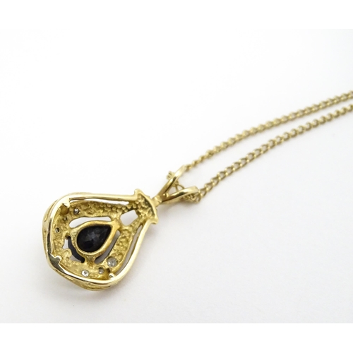 766 - A 9ct gold pendant set with central dark blue stone and chip set diamonds together with a gilt and w... 