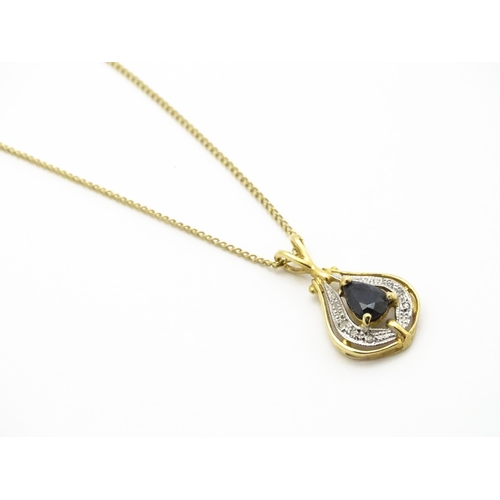 766 - A 9ct gold pendant set with central dark blue stone and chip set diamonds together with a gilt and w... 