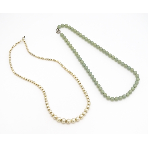 768 - A graduated pearl necklace with 9ct gold clasp. Together with a jade green coloured glass bead neckl... 