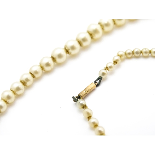 768 - A graduated pearl necklace with 9ct gold clasp. Together with a jade green coloured glass bead neckl... 