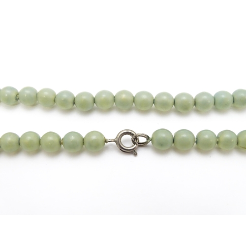 768 - A graduated pearl necklace with 9ct gold clasp. Together with a jade green coloured glass bead neckl... 