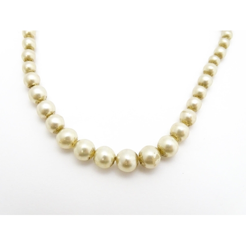 768 - A graduated pearl necklace with 9ct gold clasp. Together with a jade green coloured glass bead neckl... 