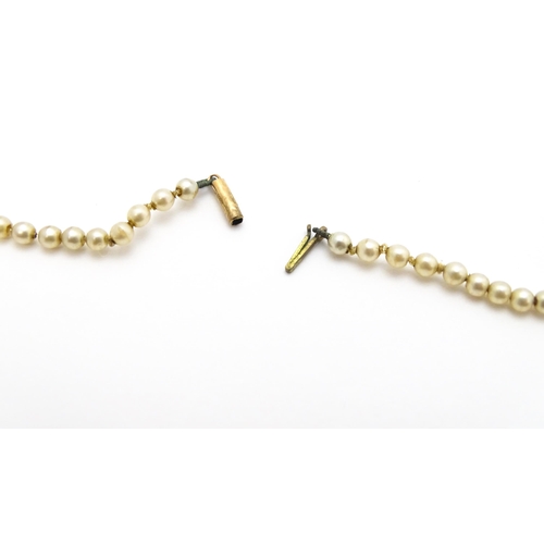 768 - A graduated pearl necklace with 9ct gold clasp. Together with a jade green coloured glass bead neckl... 