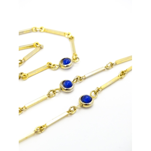 769 - A gilt metal chain necklace set with blue beads. Together with a gilt metal ring set with three whit... 