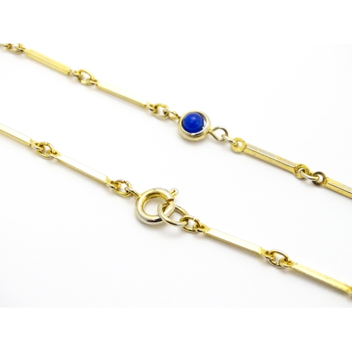 769 - A gilt metal chain necklace set with blue beads. Together with a gilt metal ring set with three whit... 