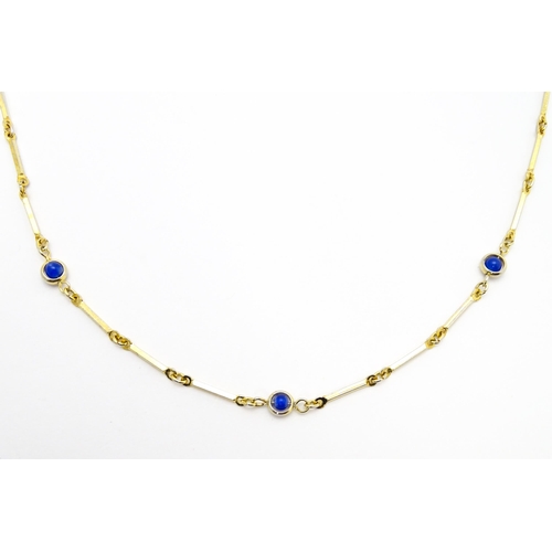 769 - A gilt metal chain necklace set with blue beads. Together with a gilt metal ring set with three whit... 