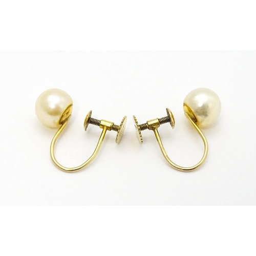 770 - A pair of 9ct gold screw back earrings set with pearls