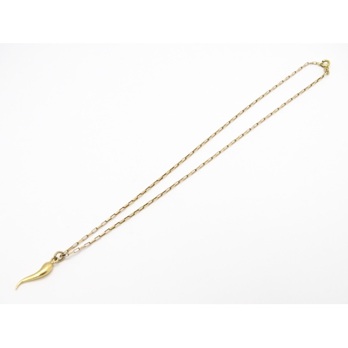 771 - A yellow metal pendant formed as an Italian twisted horn, on a 9ct gold chain. Pendant approx. 1