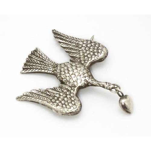 774 - A white metal sweetheart brooch formed as a bird / dove with heart drop to beak1 1/2