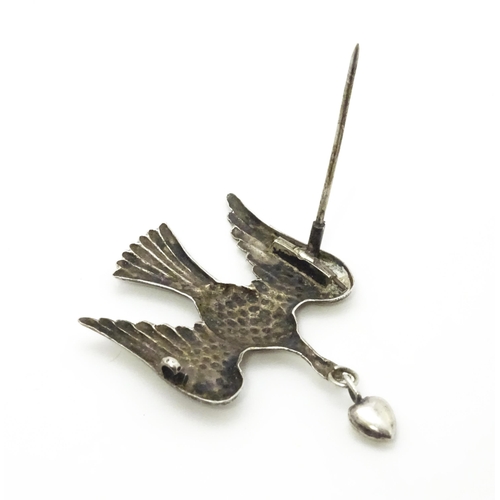 774 - A white metal sweetheart brooch formed as a bird / dove with heart drop to beak1 1/2