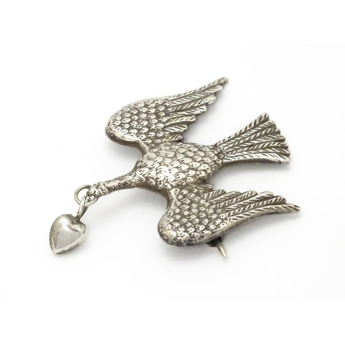 774 - A white metal sweetheart brooch formed as a bird / dove with heart drop to beak1 1/2