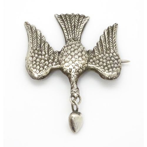 774 - A white metal sweetheart brooch formed as a bird / dove with heart drop to beak1 1/2