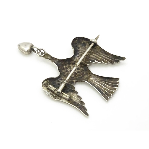 774 - A white metal sweetheart brooch formed as a bird / dove with heart drop to beak1 1/2