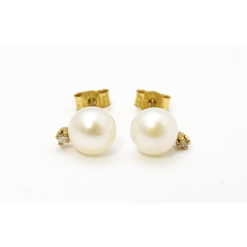 775 - A pair of 9ct gold stud earrings set with pearl and diamond