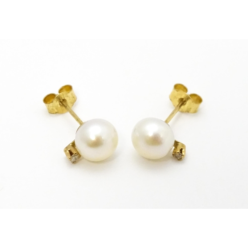 775 - A pair of 9ct gold stud earrings set with pearl and diamond