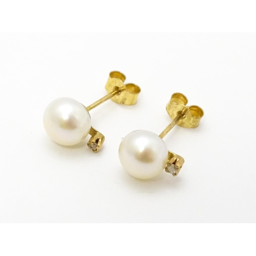 775 - A pair of 9ct gold stud earrings set with pearl and diamond