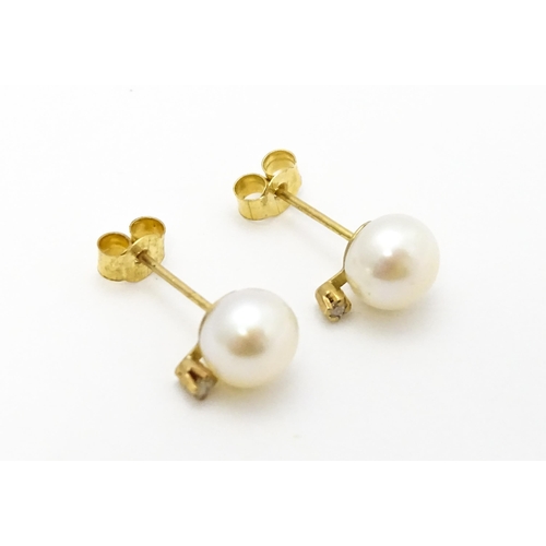 775 - A pair of 9ct gold stud earrings set with pearl and diamond