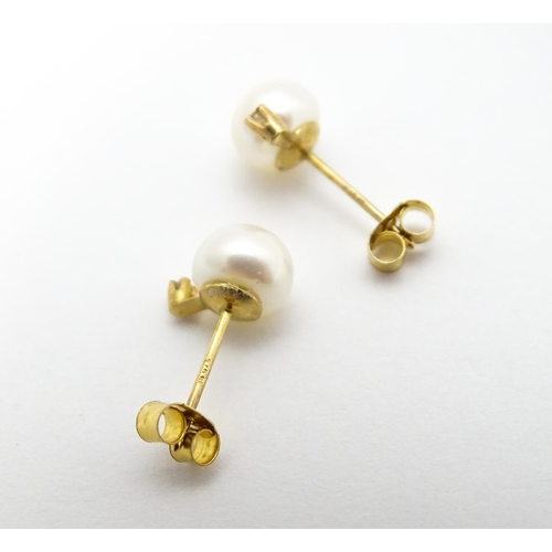 775 - A pair of 9ct gold stud earrings set with pearl and diamond