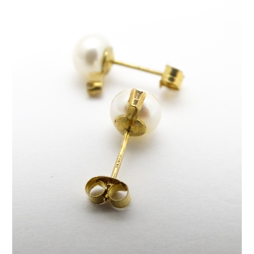 775 - A pair of 9ct gold stud earrings set with pearl and diamond