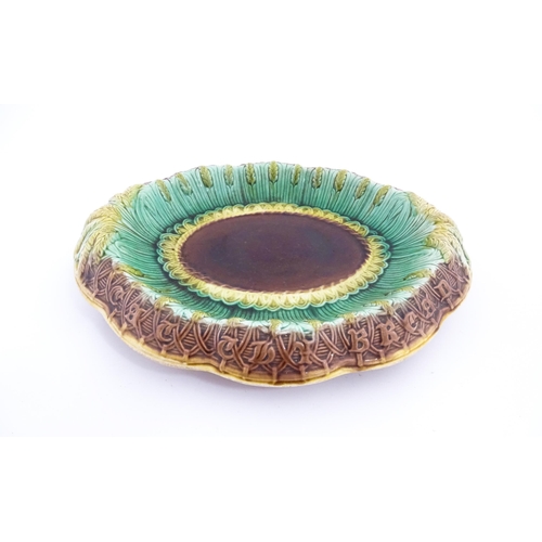 150A - A Victorian majolica bread plate, the inner rim decorated with wheat sheaves, the outer edge bearing... 