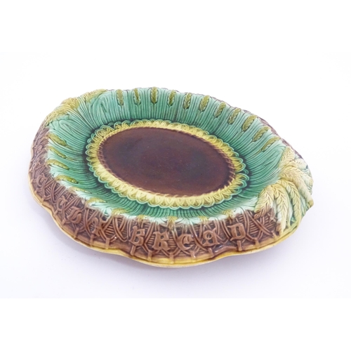 150A - A Victorian majolica bread plate, the inner rim decorated with wheat sheaves, the outer edge bearing... 