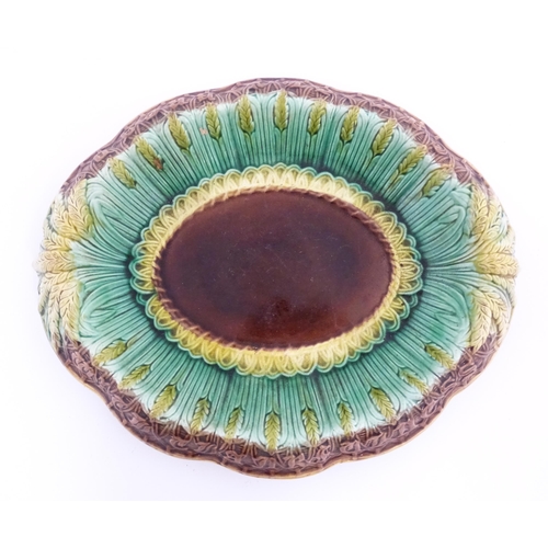 150A - A Victorian majolica bread plate, the inner rim decorated with wheat sheaves, the outer edge bearing... 