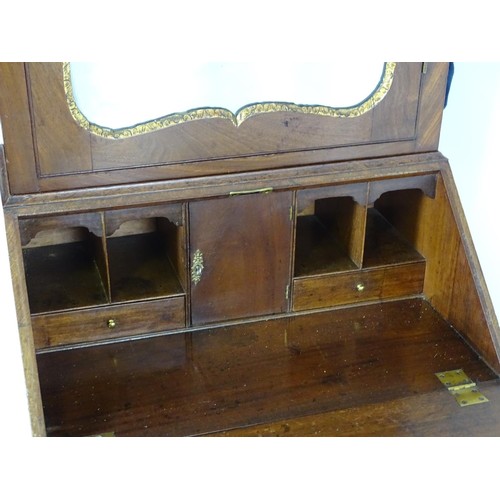 1533 - A mid 18thC mahogany bureau bookcase with a moulded cornice above a dentil frieze and shaped mirrore... 