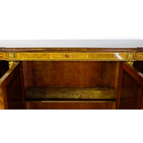 1544 - A Victorian burr walnut credenza with a bowed front and moulded top above an intricately inlaid stru... 