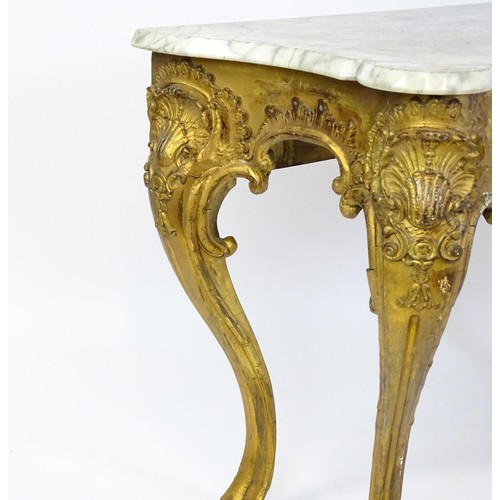 1573 - A 19thC marble topped table with a gesso and giltwood moulded base, decorated with shells, flowers, ... 